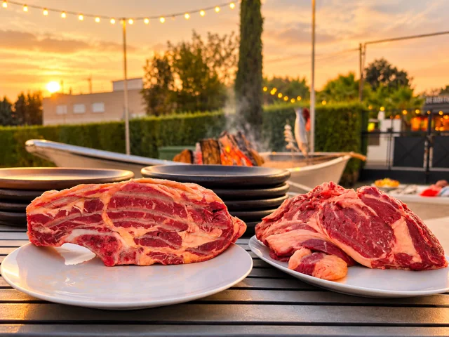 Piezas de carne preparadas junto a la barca de brasas