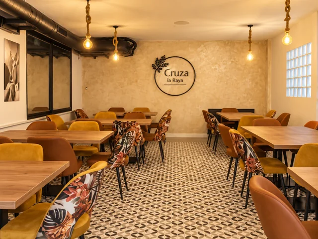 Sala con sillas de colores cálidos y rótulo del restaurante